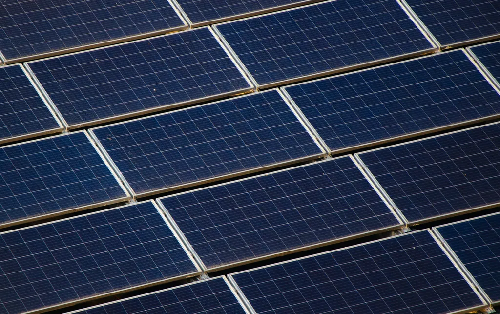 Close view of solar panel rows under a bright sky