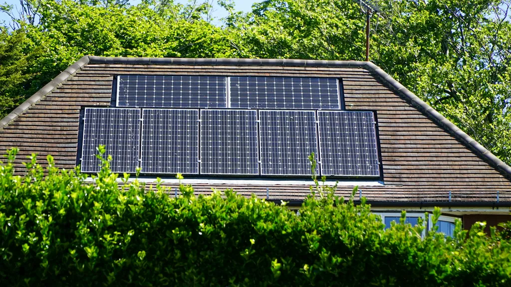 A brick bungalow with solar panels across its tiled pitched roof