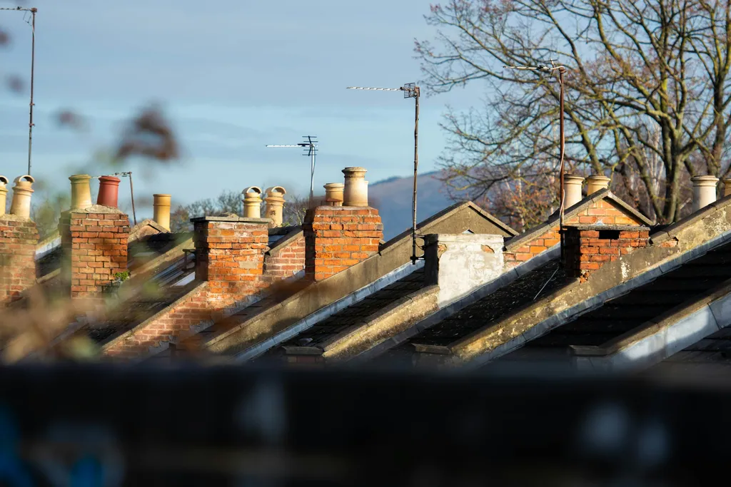 Chimneys and slate rooflines along a row of terraced houses
